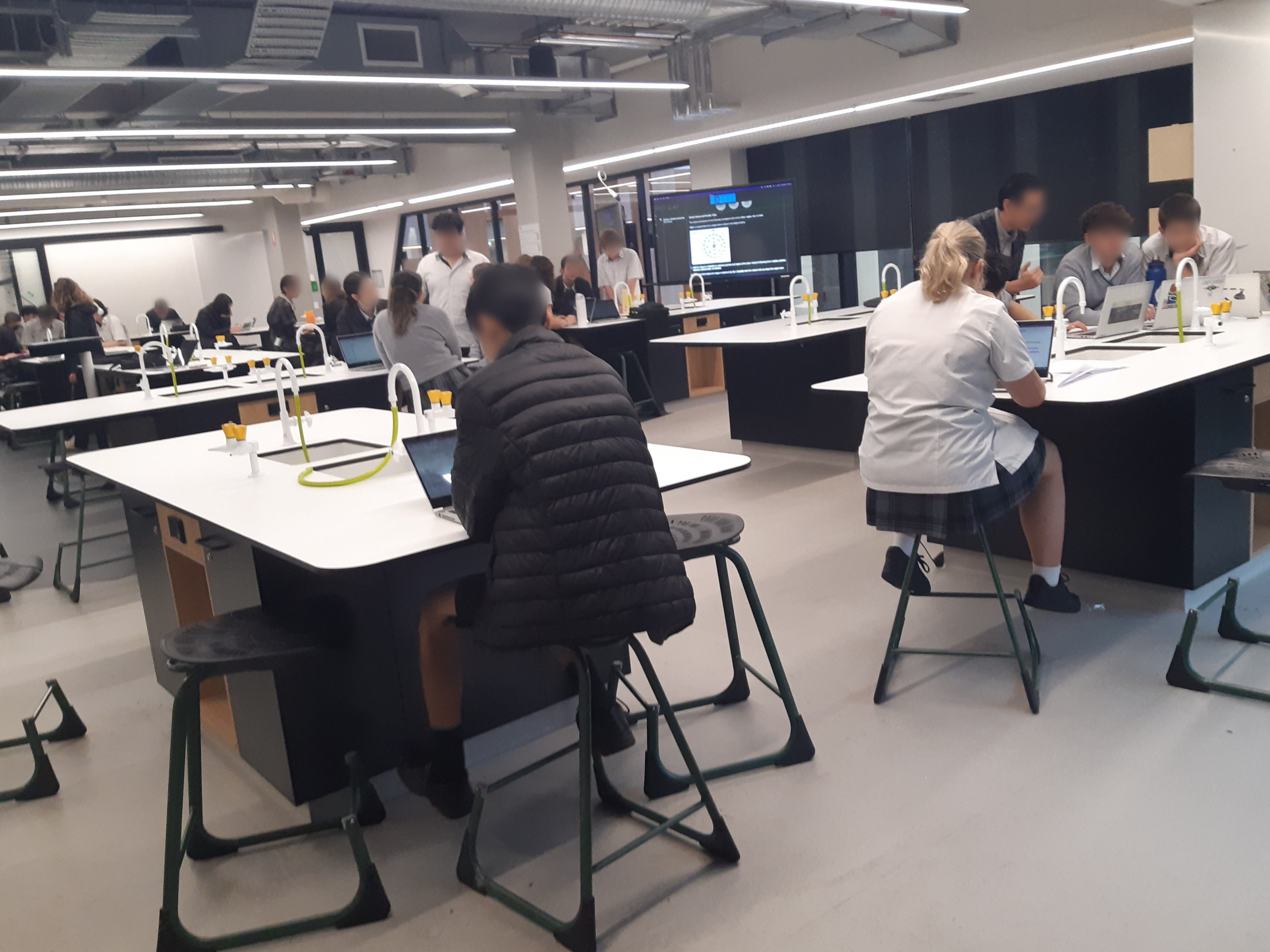 student sitting on stools