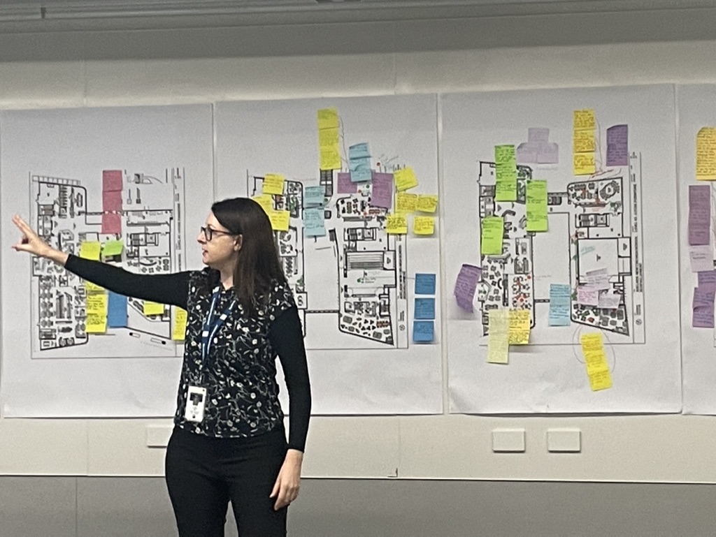 researcher pointing in front of a messy whiteboard