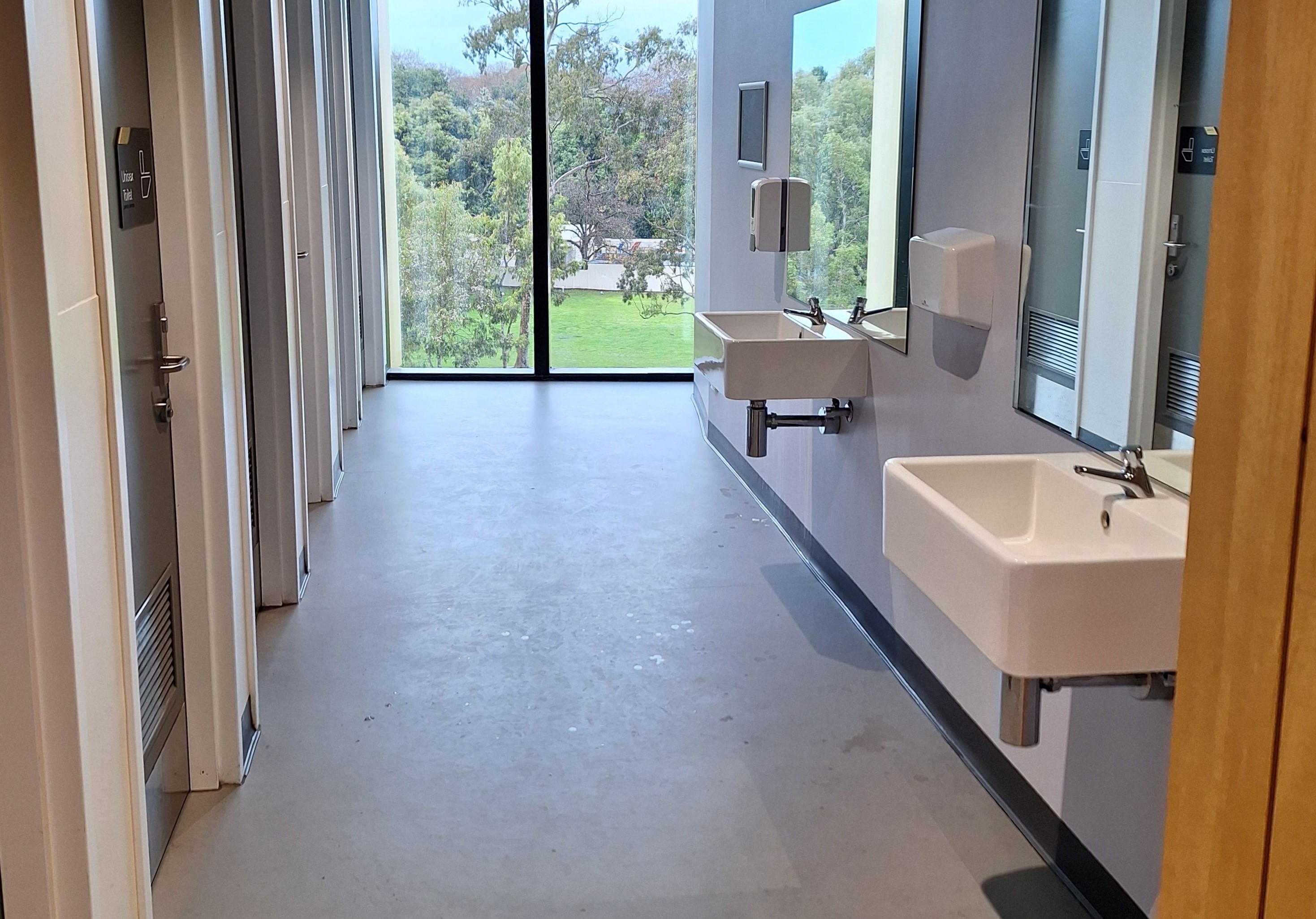 washroom with sinks and doors leading to toilet stalls